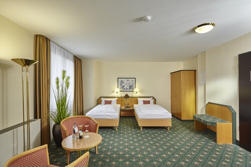 Komfort Twinzimmer im Balance Hotel Leipzig Stötteritz mit zwei Einzelbetten, modernem Interieur, Balkon und Blick auf den Garten