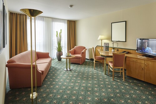 Wohnzimmer einer großzügigen Suite im Balance Hotel Leipzig mit stilvoller Einrichtung, separatem Wohnbereich, ruhiger Gartenseite und moderne Ausstattung